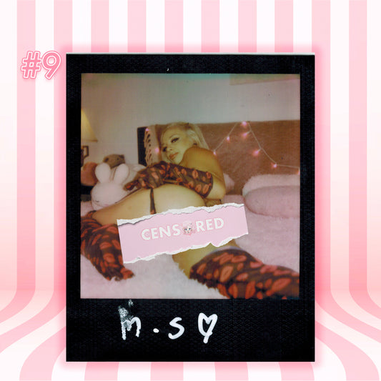 A Polaroid-style photo print featuring a woman reclining on a bed, wearing leopard-print thigh-high stockings and a black thong, with a pink censor bar overlay reading 'CENSORED'. The print is centered on a pink striped background with the text 'M.
