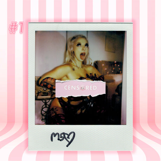 A Polaroid-style photo print centered on a pink striped background. The print shows a blonde woman in a black lace outfit with a torn pink label reading 'CENSORED' across the middle.